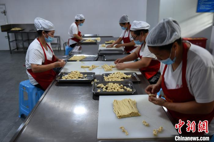 图为工人们正在搓麻花。　周毅　摄