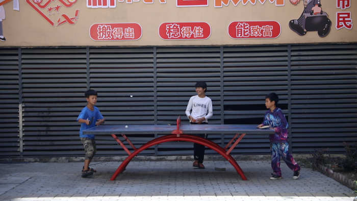 贵州省遵义市桐梓县柏果树社区易地扶贫搬迁安置点上的儿童在打乒乓球 工人日报记者 雷宇翔 摄