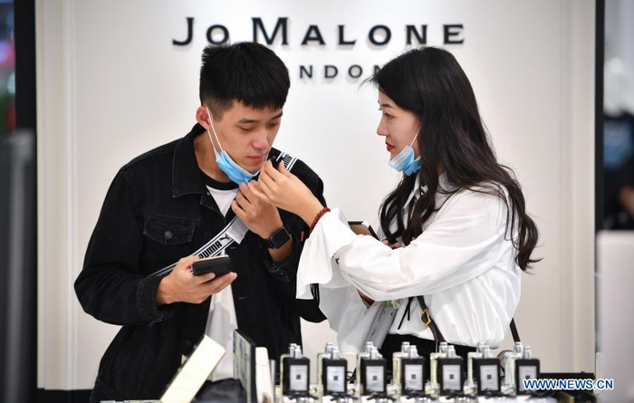 A customer selects perfume products at a duty-free shop in Haikou, capital of south China's Hainan Province Jan. 7, 2021. Offshore duty-free shops in China's island province of Hainan have raked in more than 32 billion yuan (about 4.9 billion U.S. dollars) in sales in 2020. (Xinhua/Guo Cheng)
