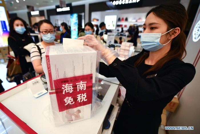 A sales assistant packs purchased products at a duty-free shop in Haikou, capital of south China's Hainan Province Jan. 7, 2021. Offshore duty-free shops in China's island province of Hainan have raked in more than 32 billion yuan (about 4.9 billion U.S. dollars) in sales in 2020. (Xinhua/Guo Cheng)