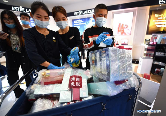Sales assistants arrange purchased products at a duty-free shop in Haikou, capital of south China's Hainan Province Jan. 7, 2021. Offshore duty-free shops in China's island province of Hainan have raked in more than 32 billion yuan (about 4.9 billion U.S. dollars) in sales in 2020. (Xinhua/Guo Cheng)