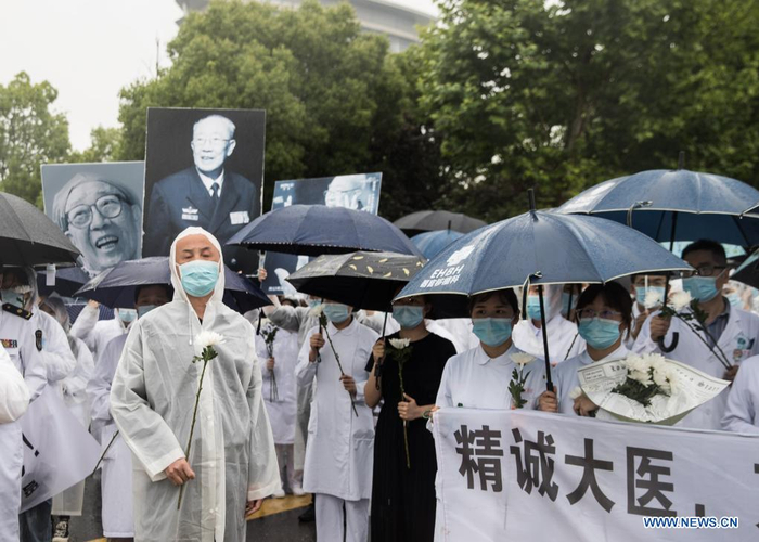 Medical workers bid farewell to deceased China's top hepatobiliary surgeon Wu Mengchao as the hearse slowly passes in Eastern Hepatobiliary Surgery Hospital in east China's Shanghai, May 26, 2021. A memorial service for Wu Mengchao, known as the 