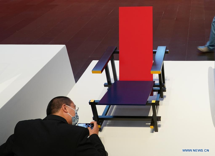 A visitor takes photos of an artwork by Gerrit Thomas Rietveld at an exhibition in Tsinghua University Art Museum in Beijing, capital of China, June 3, 2021. Displaying a total of 158 modern designs, the exhibition named 
