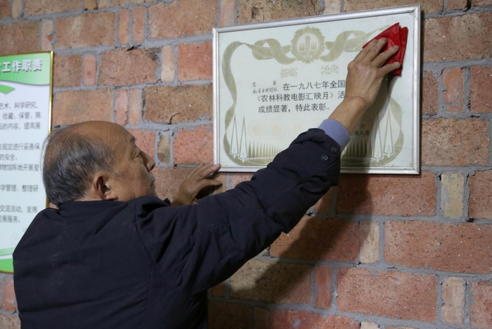 谢玉年擦拭奖状（央广网发 赵军摄）