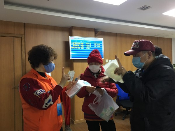 图说：助聋志愿者引导听障人士就医。张慧芬 摄