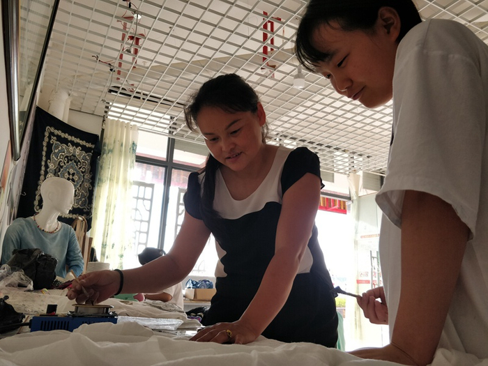 镇宁自治县巧手民族蜡染刺绣工艺坊总经理梁海兰（左一）。（央广网发 曾实 摄）