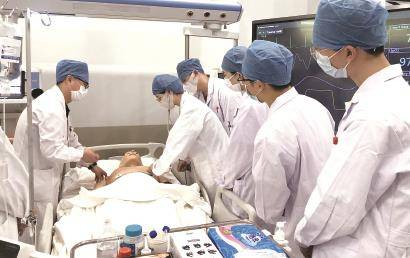 老师指导学生进行人体体格检查操作。