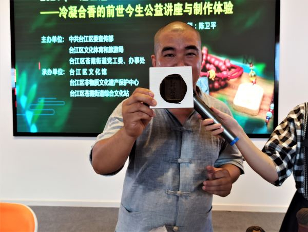 　　陈卫平老师展示现场制作的带有“七溜八溜不离虎纠”字样的冷凝合香（央广网发 罗晓英摄）
