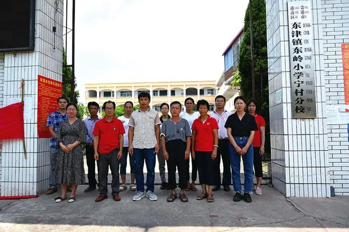 ▲回访当日，宁村小学老师们在校门前合影