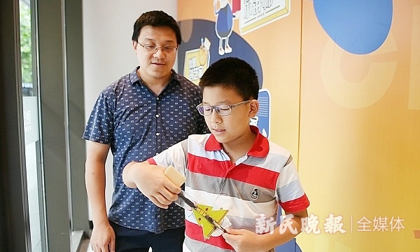 图说：和田路小学四年级男孩徐弈茗不仅给黑板擦装了自动吸尘装置，将黑板擦绑在家里清洗鱼缸的伸缩长杆上，这样，小个子们擦黑板也不用发愁了