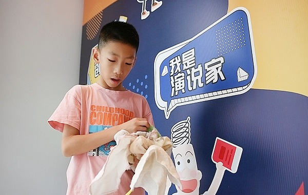 图说：三年级男孩张允赫和同学们仔细比对了市面上常见的抹布种类，几经尝试后发现，木纤维和竹纤维抹布不容易产生异味