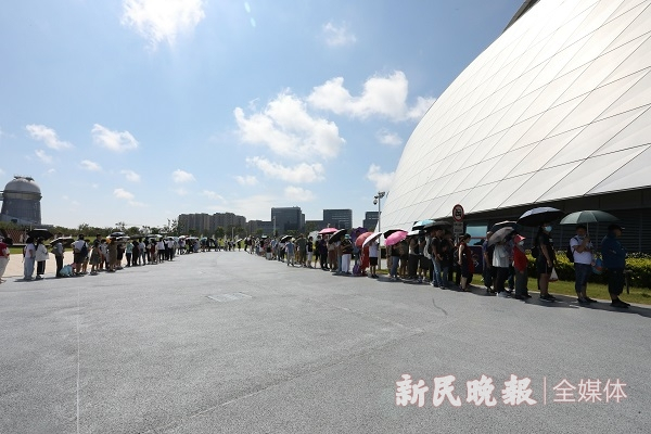 图说：不少游客冒着烈日前来排队