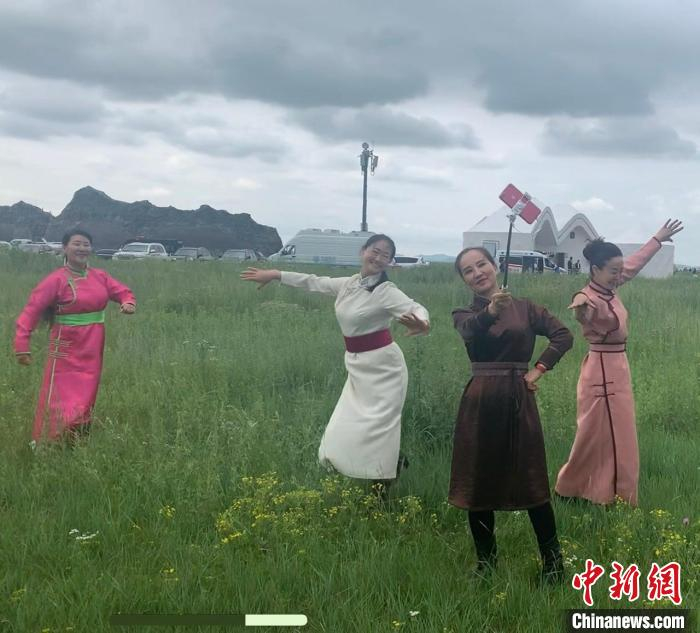 图为游客们身着蒙古族民族服饰，在金莲川草原上载歌载舞。　奥蓝 摄