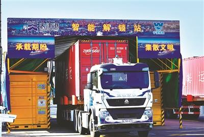 无人驾驶电动集卡经过位于天津港集装箱码头的无人智能解锁站。 （天津港集团供图）