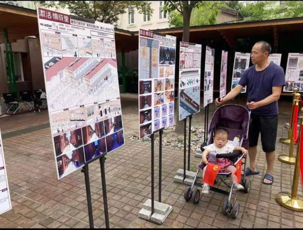 口袋广场上，居民观看征集到的设计方案展板。施佳宇图