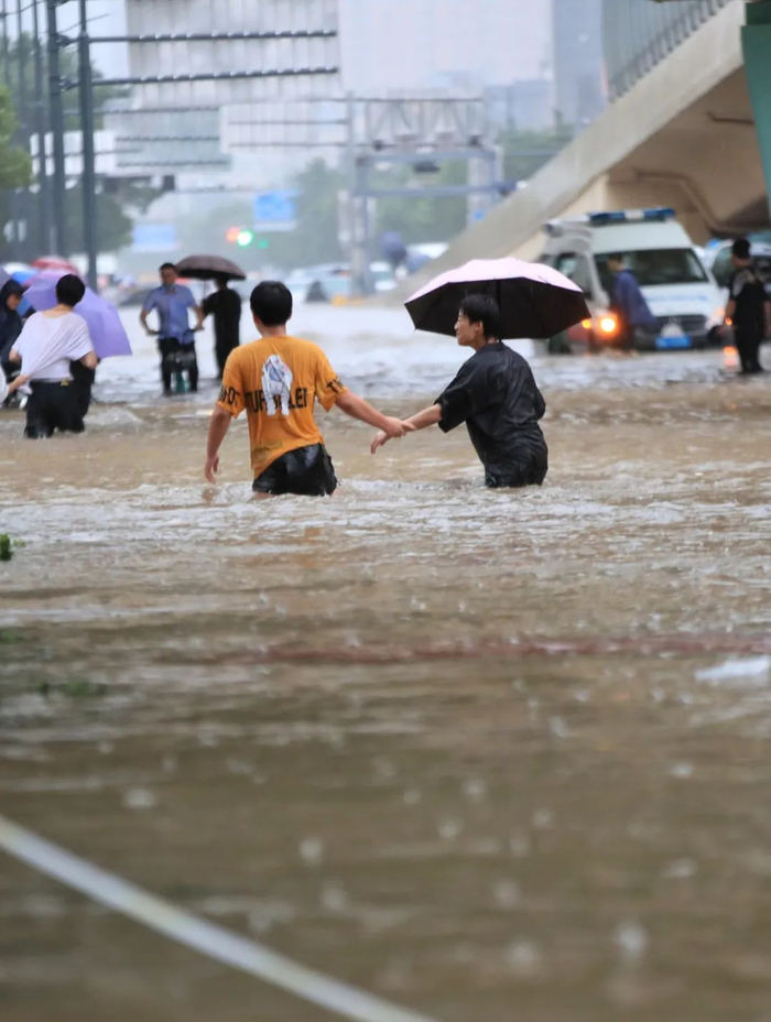 △20日，郑州遭遇强降雨，在经三路、农业路上，市民走在齐腰深的积水里。