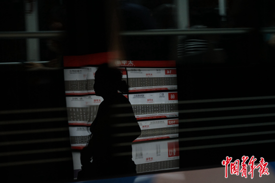     在北京公交车站等车的寻亲人李秀华。 中青报·中青网记者 李强/摄