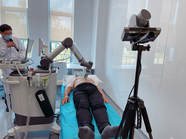 图说：中山医院的医生正远程操纵机械臂为患者做肝脏B超检查