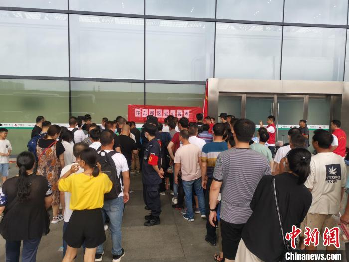 郑州东站滞留旅客正在排队取餐。　李明明 摄