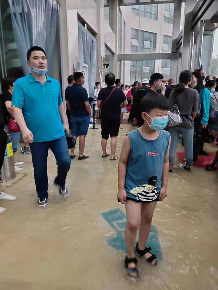 7月20日傍晚，人们在郑州大学第一附属医院观看外面的雨势，受访者供图