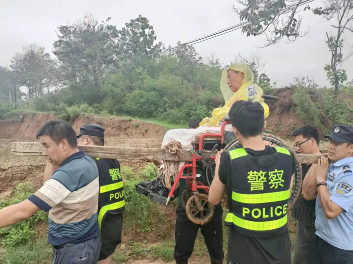 梁聚一行把老太太抬下山。受访者供图