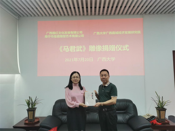广西大学县域经济发展研究院书记、执行院长彭剑啸向雕像捐赠企业赠送其著作《马君武》传（央广网发 广西大学县域经济发展研究院供图）