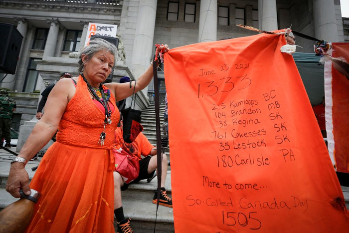 7月1日，原住民社团成员在加拿大温哥华举行的集会上展示近期加拿大多地发现原住民儿童遗骸的清单。新华社发（梁森摄）