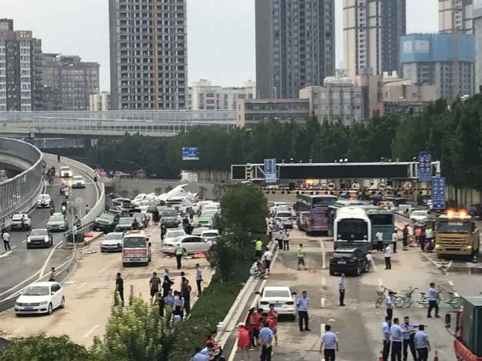 ▲22日下午，京广北路隧道口，露出水面的车堆叠在路面上。新京报记者 聂辉 摄