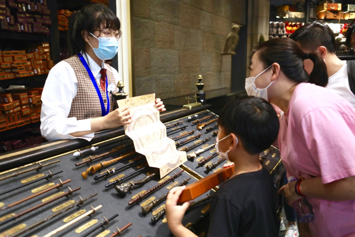 店员耐心讲解颇受欢迎的哈利波特魔法棒 张笑嫣/摄