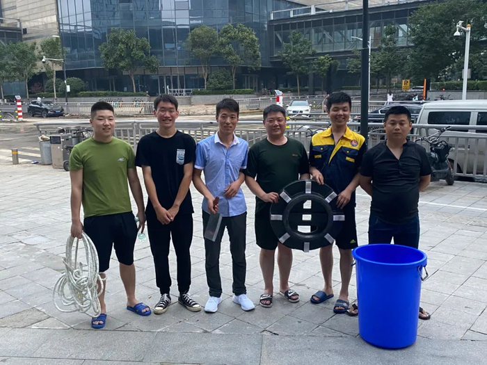 　　7月24日，部分救人者合影，身后就是砸窗救人的事发地。从左至右：王深圳，王志磊，李坤朋，樊小明，娄彦喆，殷龙飞。&nbsp; &nbsp; &nbsp;新京报记者 杨雪 摄