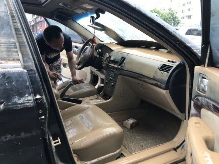 ▲7月23日，杨田帧的汽车被拖车隧道停在路边。杨田帧打开车门，拔掉被困隧道时来不及拔下的钥匙。新京报记者 聂辉 摄