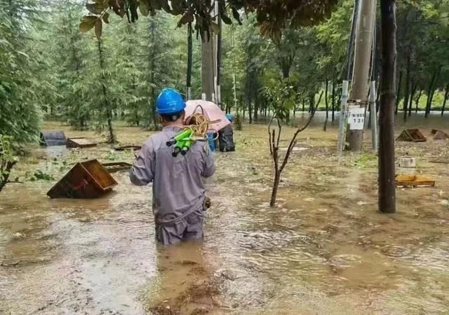 这是国网郑州供电公司员工趟着齐腰深的积水紧急抢修供电设施。