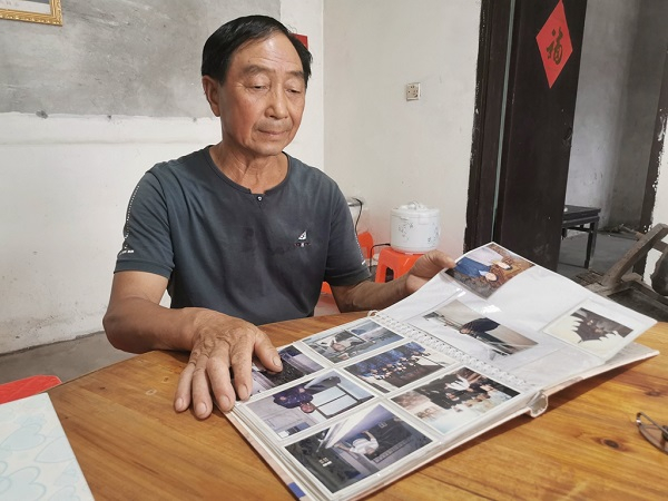 　　王锡荣翻看相册（央广网发 通讯员供图）