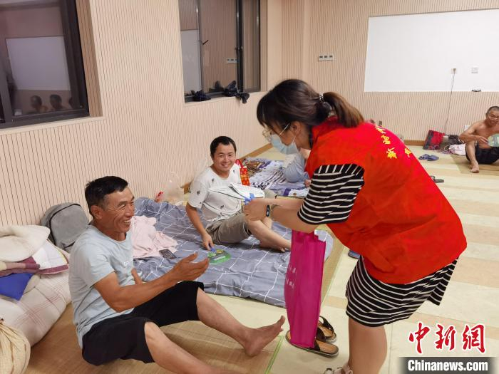 社区志愿者为安置点内的工人送上食物。孔家埭社区供图