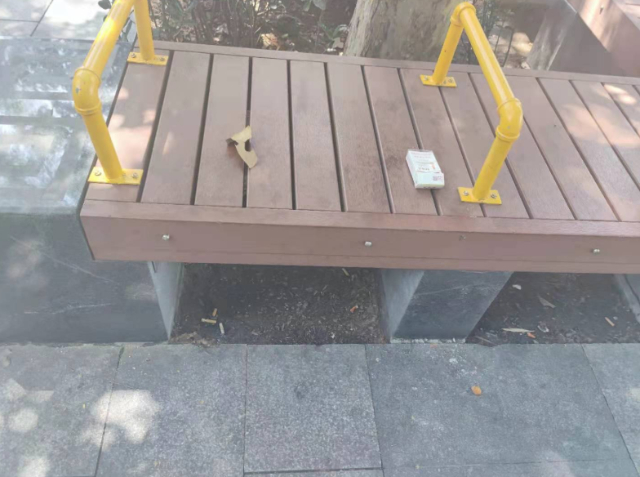 地铁东单站外林荫地座椅上的烟盒和周围的烟头