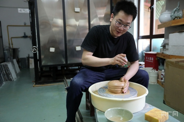 周明明在制作陶瓷过程中准备拉坯（央广网记者魏炜 摄）