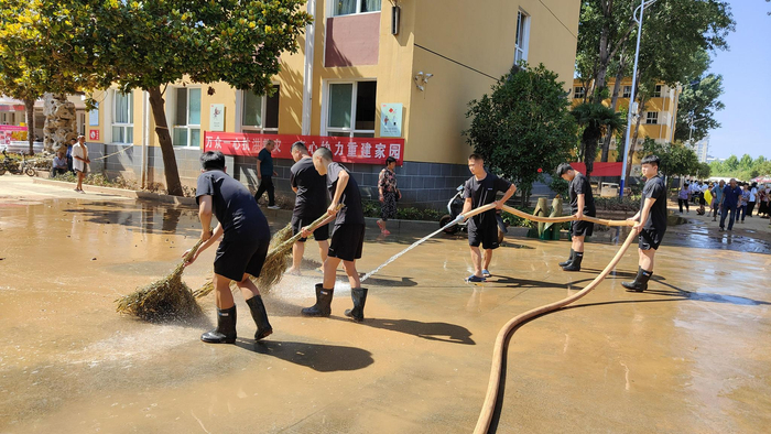 7月26日，淇县职业中专安置点内，工作人员正在清洗路面。新京报记者 刘瑞明 摄
