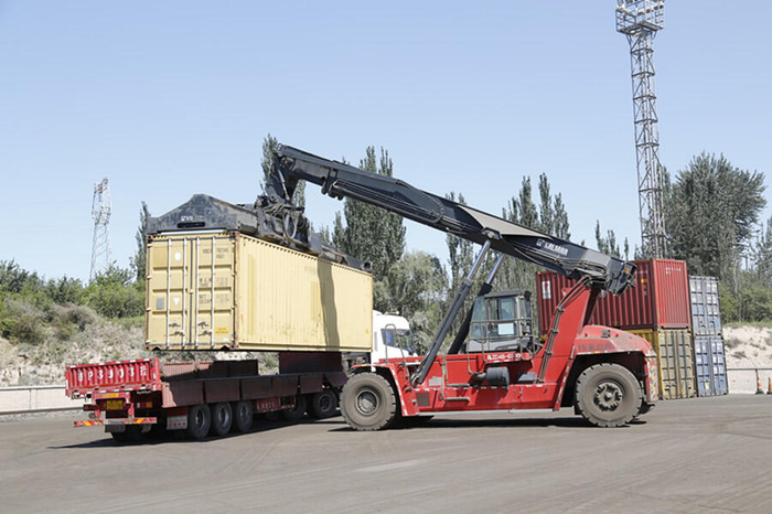 正面吊正在将“中吉哈”班列集装箱吊装至转运汽车上。央广网发