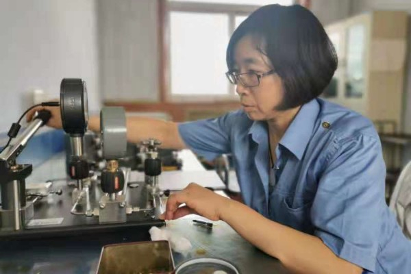 计量检定员正在进行铁路机车专用压力表的校验（太原车辆段供图）