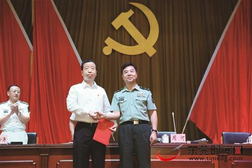 ■7月6日，东莞军分区党委第一书记任职大会召开。图为广东省军区司令员周河（右）为肖亚非颁发任职证书 首席记者 程永强 摄
