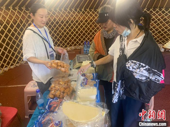 图为游客们正在选购奶食品。　奥蓝 摄