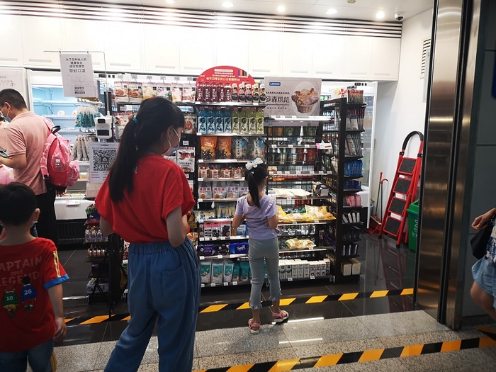 地铁乘客正在罗森便利店选购商品。