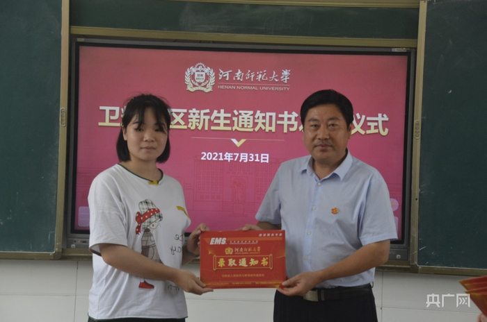  河南师范大学党委副书记陈广文为新生发放录取通知书（央广网发 吴振宇摄）