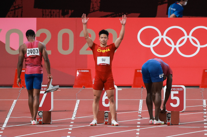 百米决赛开始前，苏炳添向全场示意。