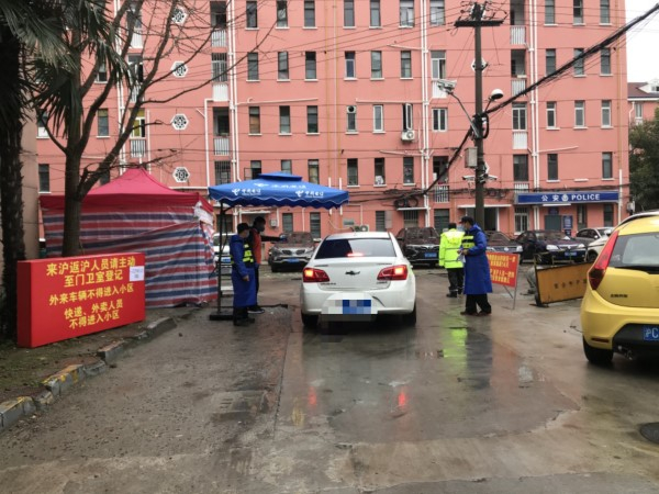 图说：疫情期间，工作人员对小区开放路口封闭管控