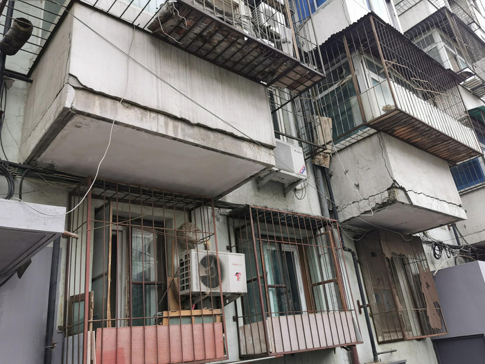小区楼体外墙遍布裂痕，墙体外立面也出现了脱落。