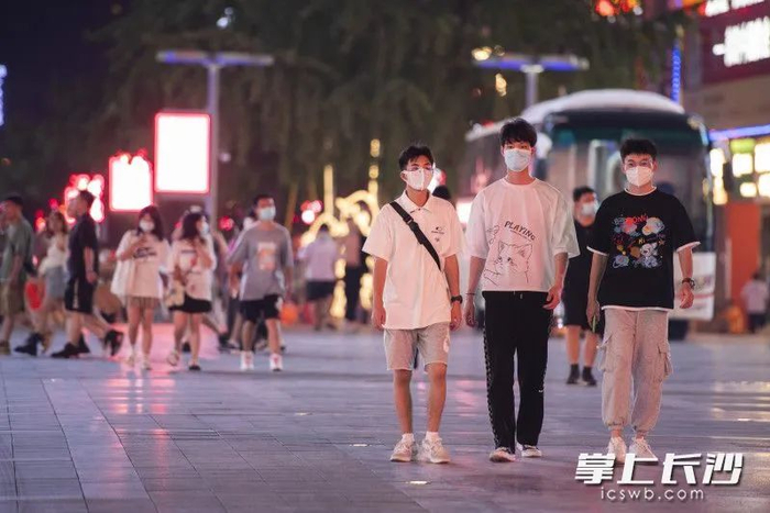 ▲ 在黄兴南路商业步行街，市民戴着口罩出行