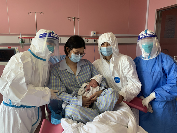 图说：谢女士一家三口与医护人员合影留念