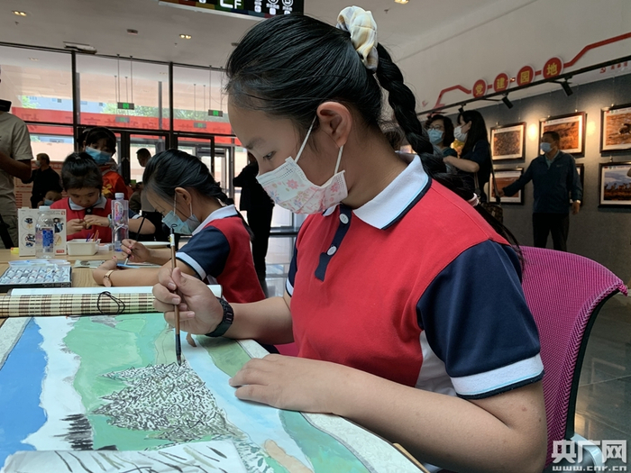 来自西宁市七一路小学的学生在展览现场绘画作品《苍翠祁连》（央广网发 汪晓青 摄）