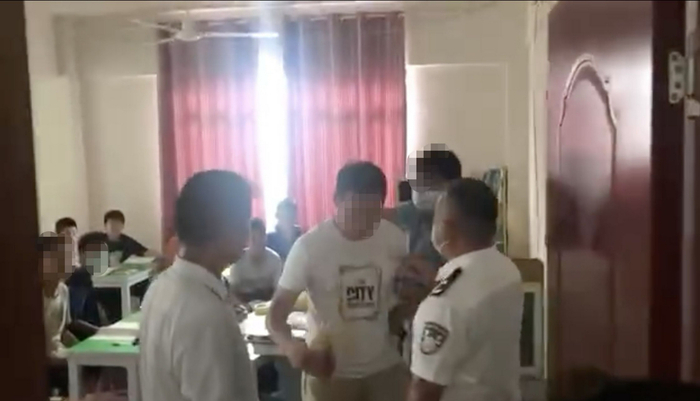 8月5日，违规补课的老师贾某某被带出教室。网络视频截图